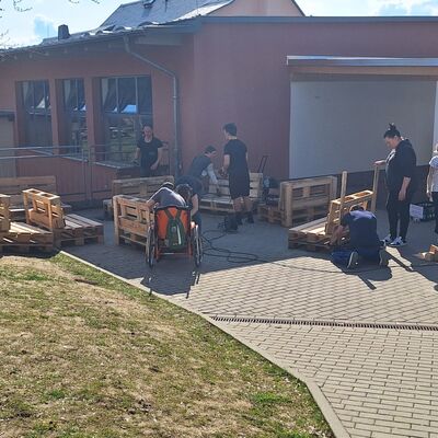 Bild vergr&ouml;&szlig;ern: Eltern udn Kinder beim Herstellen von Palettensofas