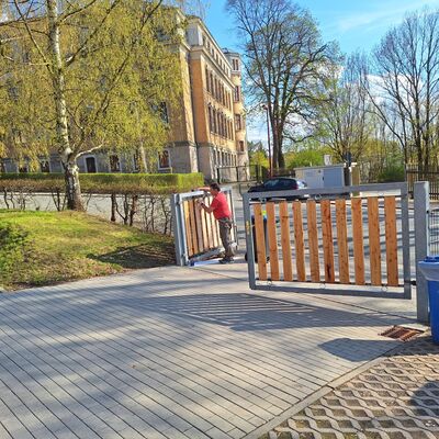 Bild vergr&ouml;&szlig;ern: Lehrer beim Streichen des Gartentores