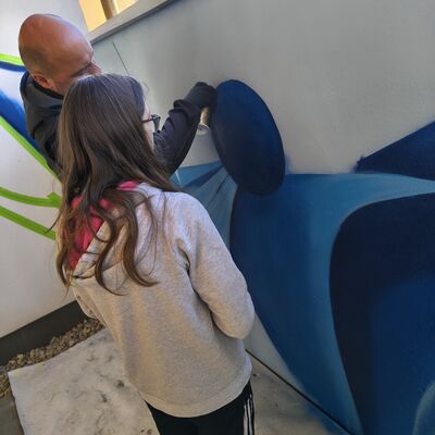 Bild vergr&ouml;&szlig;ern: Sch&uuml;lerin mit K&uuml;nstler beim Graffitispr&uuml;hen